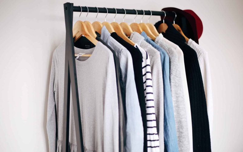 Clothing rack holds various sweaters. Clothing rack holds various sweaters.